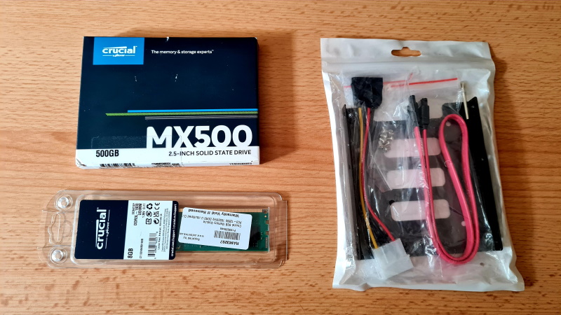 Photo showing parts for the upgrade.  An SSD, A stick of RAM and a mounting kit.